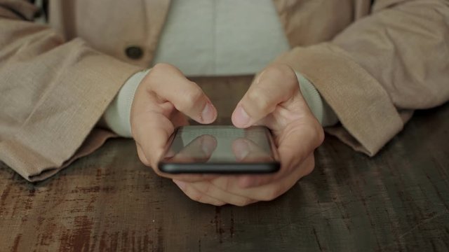 Close up of female hands and fingers typing on smartphone screen. concept connectivity and social media addiction, using application to stay in touch with friends and family