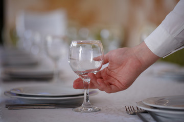 waiter holding an empty wine glasses