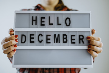 Female hands holding board writing hello december
