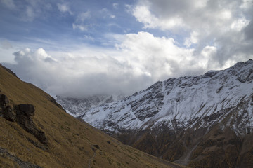 Горный пейзаж. Красивый вид на живописное ущелье, белые облака над высокими горами. Дикая природа Северного Кавказа
