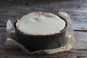 cake biscuit in split form with white cream on a woody background