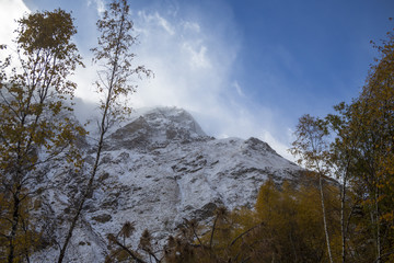 Горный пейзаж. Красивый вид на живописное ущелье, белые облака над высокими горами. Дикая природа Северного Кавказа