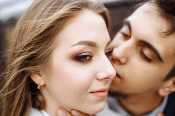 Happy hipster couple on holiday having fun and enjoy the time. Couple in love kissing and hugging. Shallow depth of field.