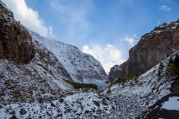 Горный пейзаж. Красивый вид на живописное ущелье, белые облака над высокими горами. Дикая природа Северного Кавказа
