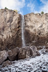 Fototapeta na wymiar Красивый водопад в горном ущелье, живописная панорама, дикая природа Северного Кавказа