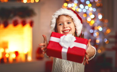 Fototapeta na wymiar happy laughing child girl with christmas present at home