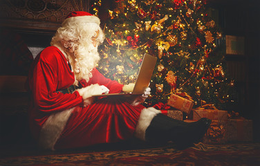 Santa Claus with  computer before christmas