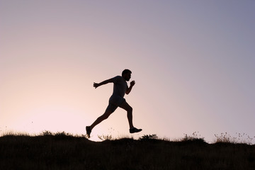 Obraz na płótnie Canvas Running man silhouette at sunset