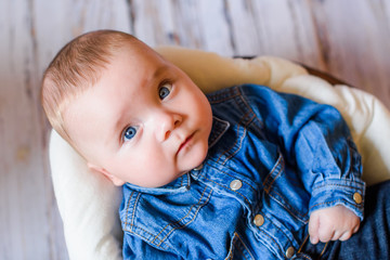 laughing newborn boy on wooden background on floor. Little caucasian child natural  wooden background indoor. happy infant Kid boy having fun at home