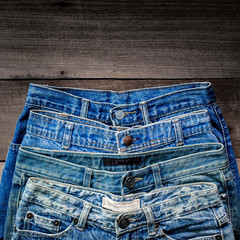 Blue jean and jean lack texture on the wooden floor, Pattern of blue jeans are overlapping on the...
