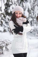 Obraz premium Happy woman on the winter background. Young pretty girl in the woods outdoors. Portrait of a cheerful beautiful woman.