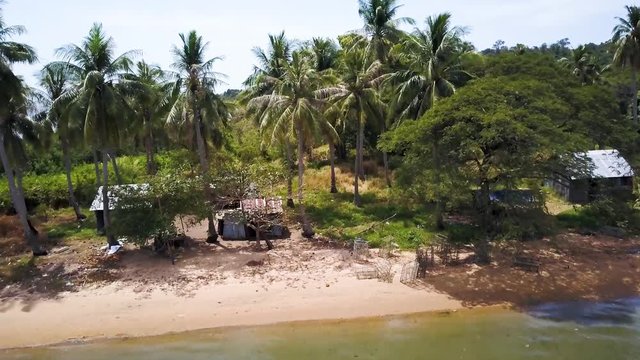 Aerial camera pushing in to a fishing village on a beach on Koh Tonsay, Rabbit Island, Cambodia.