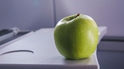 a green apple on the table of airplane