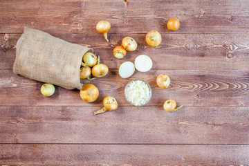 various fresh onions on a wooden table background. wallpaper for grocery shopping and cooking food concept. top view, flat lay