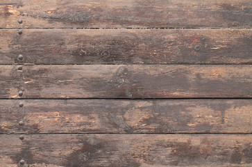 brown wooden background with nails on one side