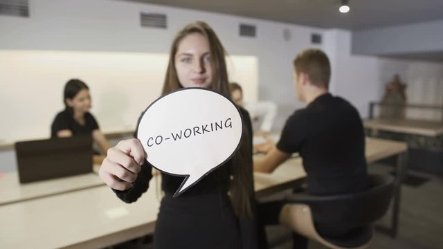 Woman with paper with "Co-working" inscription