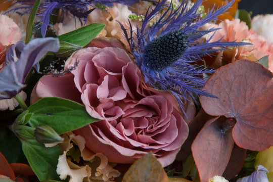 Rose and eringium flowers in florist bouquet closeup background