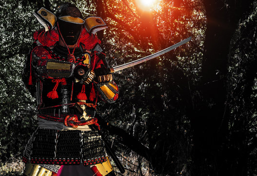 Samurai warrior with sword at sunset, isolated on the black background.