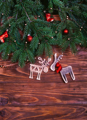 Christmas garland with red bells and two deer on wooden background. Flat lay, top view