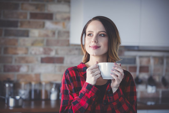 Portrait of young woman with cup of tea or coffee