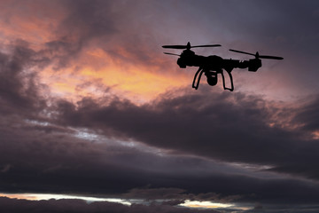 Innovation concept. Silhouette of drone flying on sunset. Heavy lift drone photographing