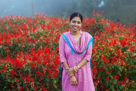 Woman in churidaar smiling in a garden