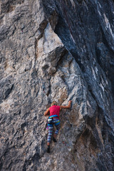 The girl climbs the rock.