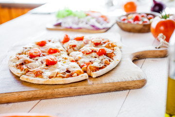 hot fresh homemade traditional italian pizza on wooden table. wallpaper for pizzeria and cooking food concept