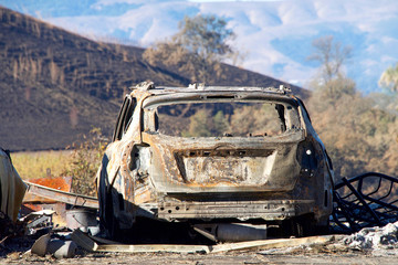 Car burned in the North Bay firestorm, charred landscape in the background.