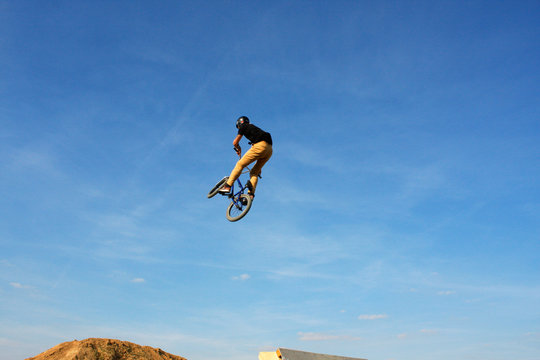 man in sportswear jumping high on mountain bicycle on background of landscape.
