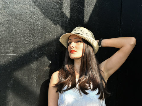 Portrait of a beautiful girl near the black wall.
