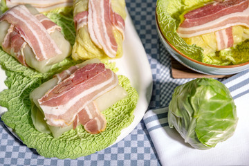 Zubereitung von Wirsingrouladen mit Speck auf Kohlblättern