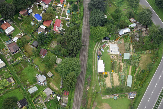 Luftaufnahme von Schrebergärten in Süddeutschland zwischen einer Landstraße und einer Bahnlinie 