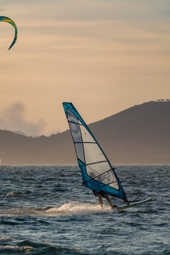 Sunset over the sea or ocean and extreme freestyle sport windsurfing