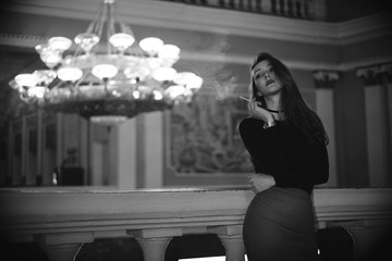 Retro black and white portrait of a beautiful Gatsby woman in luxury interior. Vogue fashion style and smoke