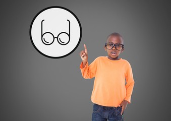 Boy against grey background with glasses pointing up at glasses