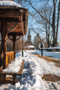 Winter walk in a snow-covered street with a traditional wooden Church at the Village Museum in Bucharest, Romania