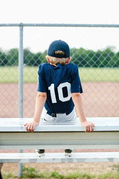 Young baseball player sitting on the bench
