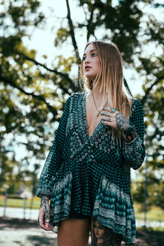 Young tattooed girl skate boarding around town.