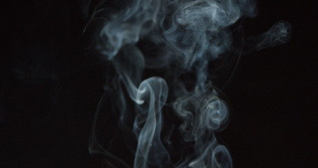 Puffing white smoke over a dark background