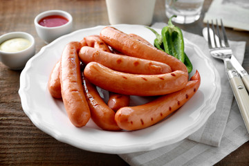 Plate with delicious grilled sausages on table