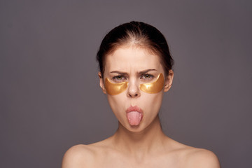 woman with cosmetic patches on her face teases