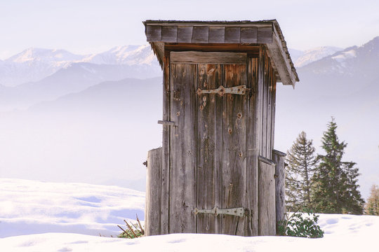 Old outhouse in the alps with snow