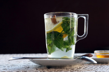 Cup of tea with lemon, mint, cinnamon and dessert