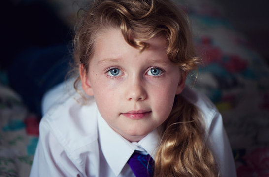 Portrait of a girl in school uniform laying on the bed
