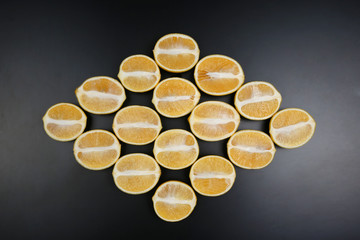 sliced lemons in a diamond shape on a dark background.