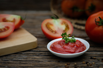 Still life of fresh ripe tomatoes sauce on wooden background,
