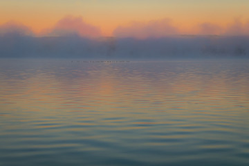 Obraz premium Fog creates a muted palette at dawn on Silver Lake, Castile, NY, in early fall