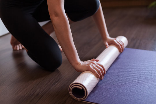 Girl fold her yoga mat