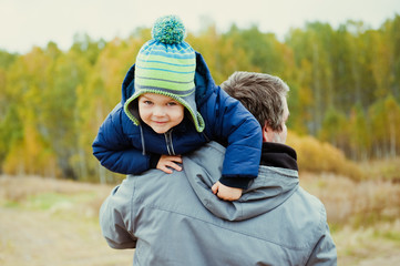 Portrait of little boy on daddy's shoulder.